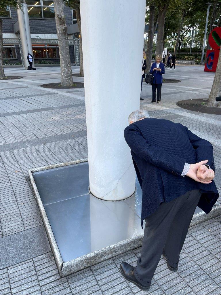 鏡を通して空へそして地球の中心に伸びる柱を眺めるパオリーニ氏