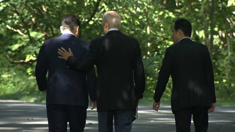 尹大統領の背に手を添えるバイデン大統領