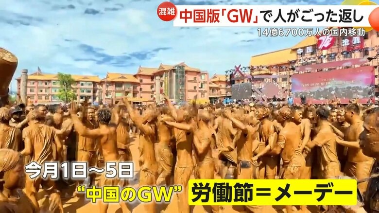 中国・雲南省の伝統的民俗行事で泥まみれで踊る人たち