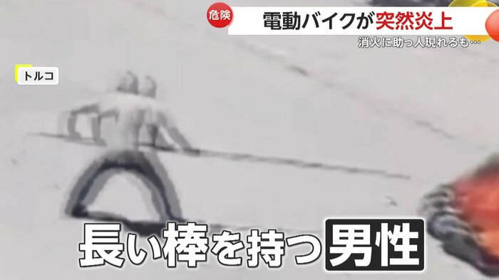 長い棒で動かそうと試みる男性