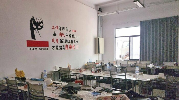 壁には「TEAM SPIRIT」と書かれ、組織的な「職場」だったことをうかがわせる