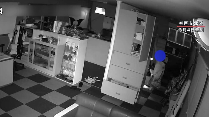 現金が入った金庫の前にしゃがみ込む男