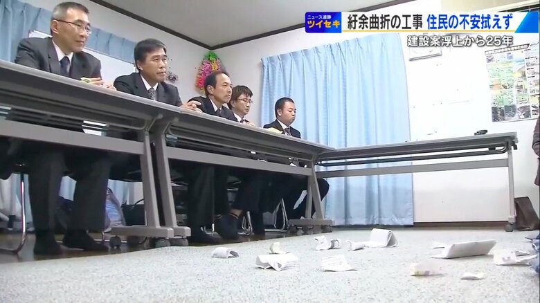 説明に不満を待った住民が破り捨てた資料が散らばる