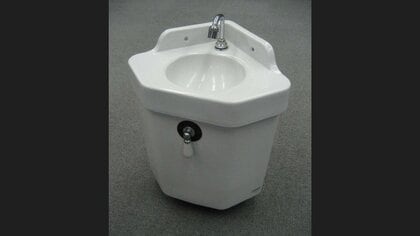 初代の手洗器付きトイレタンク。便座とは配管を通してつながっていた(提供:TOTO株式会社)