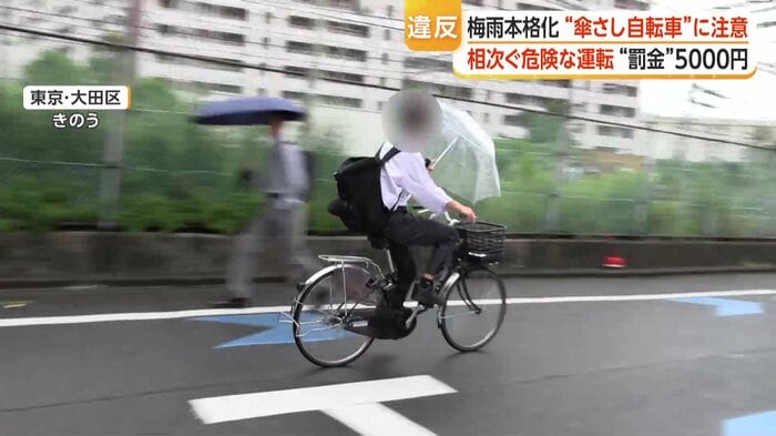 スピードを落とすことなく走り去る「傘差し運転」の自転車