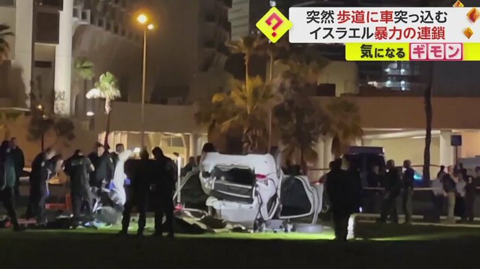 ひっくり返った車を多くの人が取り囲んでいる