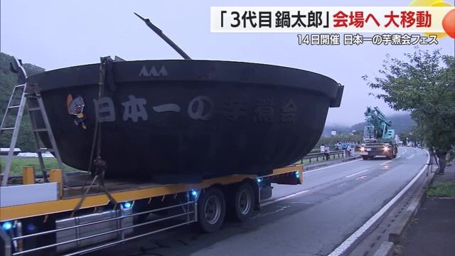 クレーン車でトレーラーに載せられ道路を移動
