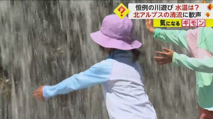 恐る恐る滝を触る子ども
