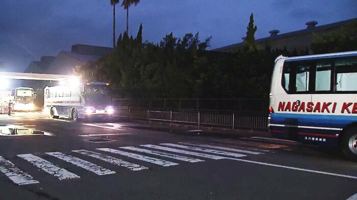 帰国が決まり下船し、空港へ向かう乗組員を乗せたバス