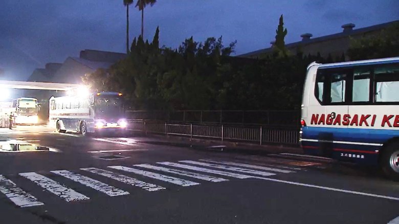 帰国が決まり下船し、空港へ向かう乗組員を乗せたバス