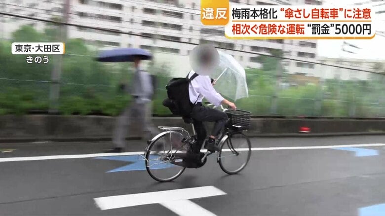 スピードを落とすことなく走り去る「傘差し運転」の自転車