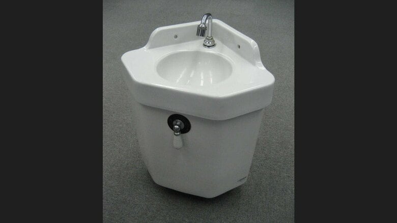 初代の手洗器付きトイレタンク。便座とは配管を通してつながっていた（提供：TOTO株式会社）