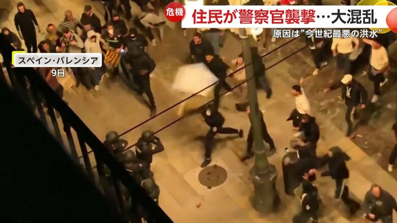 警察官に詰め寄る群集の姿（9日、スペイン・バレンシアの市庁舎広場）