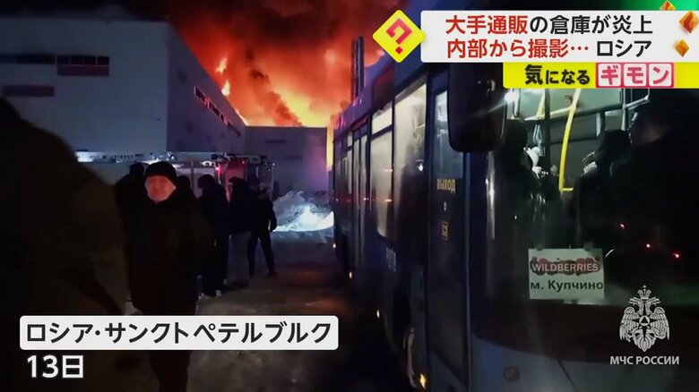 真っ赤な炎を上げて燃えている倉庫を見つめる人たち