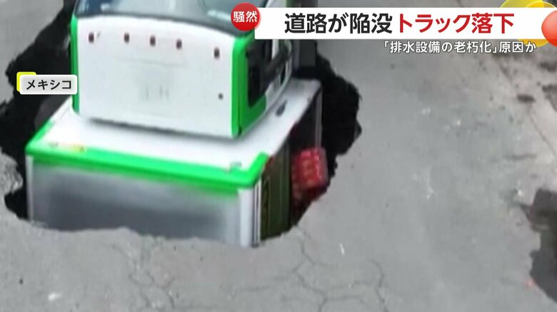 荷台の扉は開き、中から積んでいた飲み物が次々とこぼれ落ちているトラック