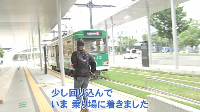 ベンチを回り込んで市電に乗ろうとする男性