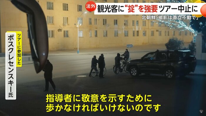 敬意を表すため自転車を降りる北朝鮮市民