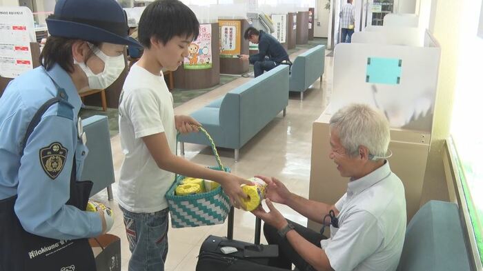特殊詐欺への注意喚起グッズを配る中島丈さん(真ん中)