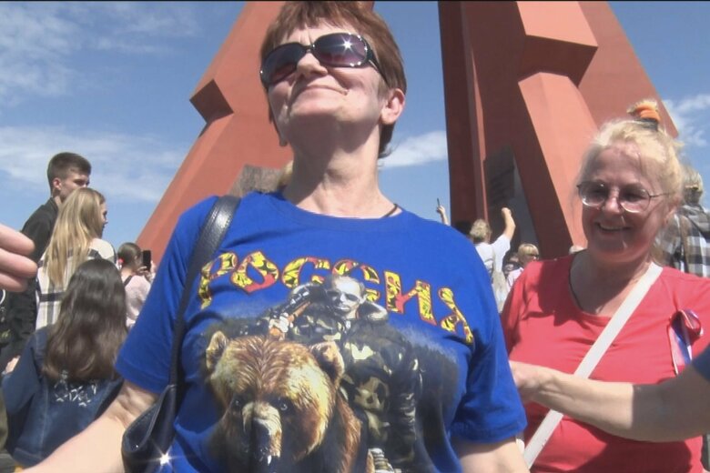 プーチン大統領と熊がプリントされたTシャツを着る親ロシア派の女性