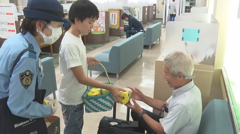 特殊詐欺への注意喚起グッズを配る中島丈さん（真ん中）