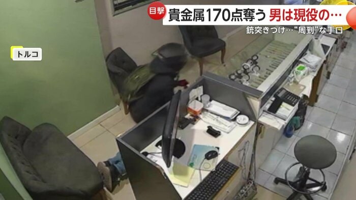 店員に乗りかかって拘束する強盗犯（IHA）