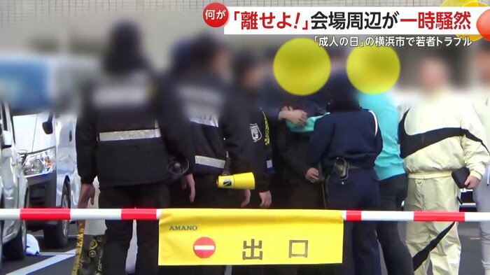 横浜アリーナの外では、スーツを着た男性グループとカジュアルな服装の男性グループがもめていた
