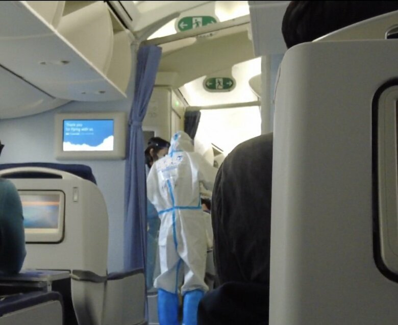 到着直後に機内に入ってきた全身防護服の係官