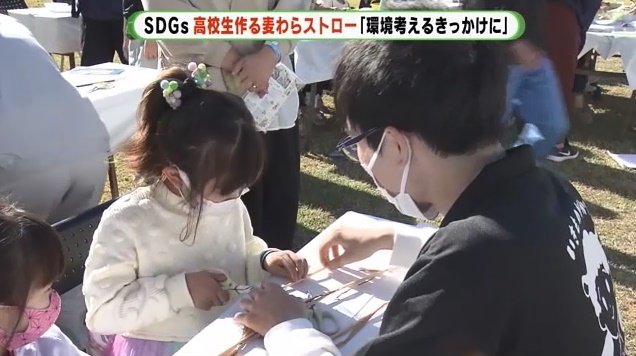 子供たちに麦わらストローの作り方を教える