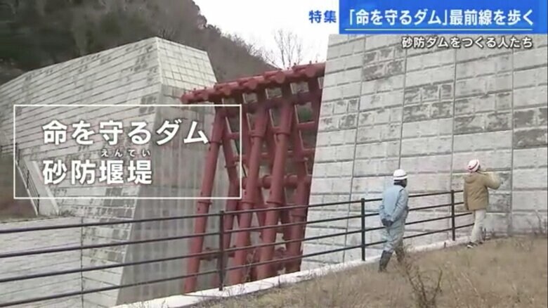 砂防ダムを間近で見る矢野記者（右）と久保さん（左）