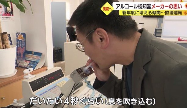 アルコール検知器の使用法を説明する杉本社長