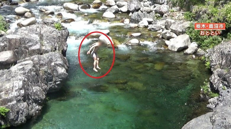 高い岩場から飛び込む男性