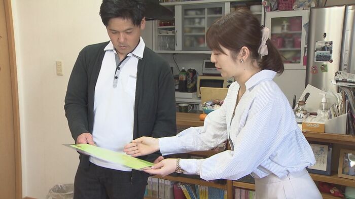 奏花ちゃんの思い出の品を見せてもらう小林アナウンサー