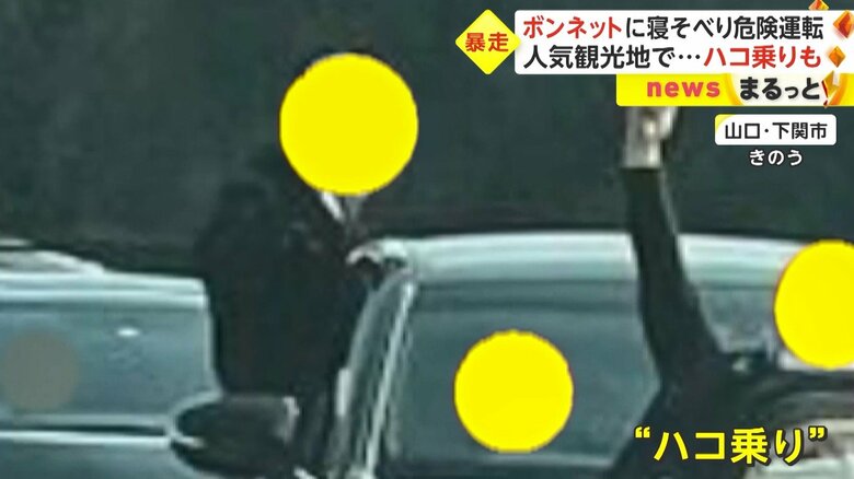 後ろでは、2人の男性が窓から身を乗り出している