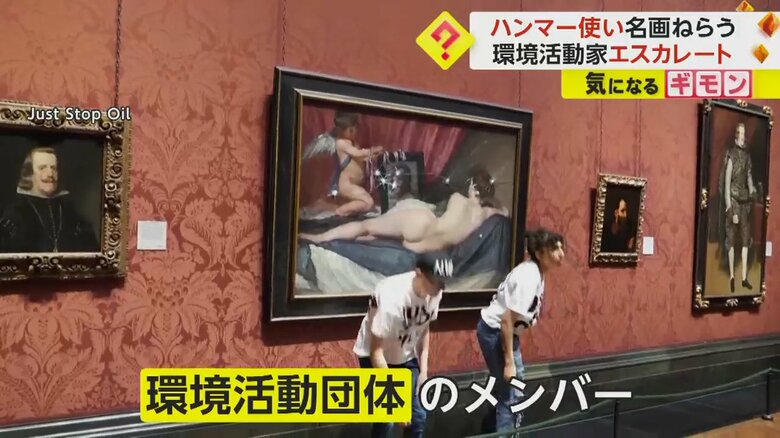 ハンマーで何度も絵を叩く環境活動団体のメンバー