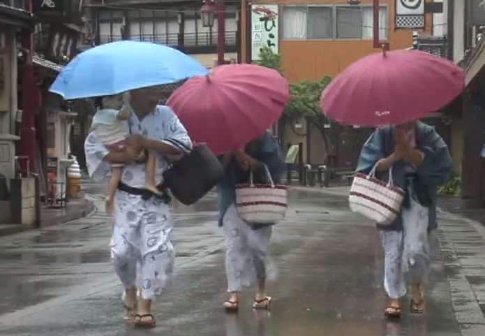 台風の中”外湯めぐり”をする観光客