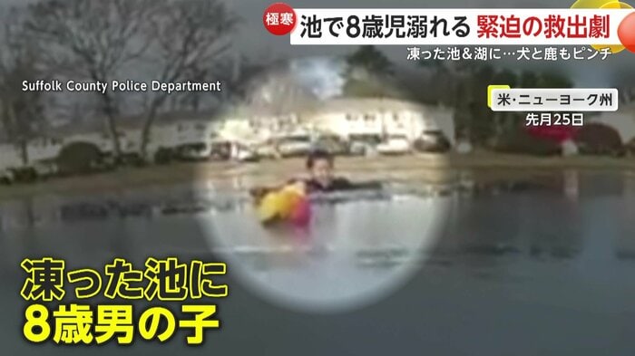 凍った池の中から顔をのぞかせる男の子