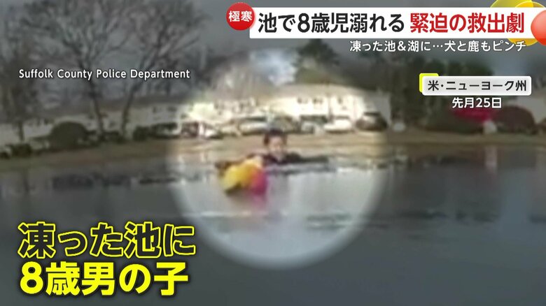 凍った池の中から顔をのぞかせる男の子