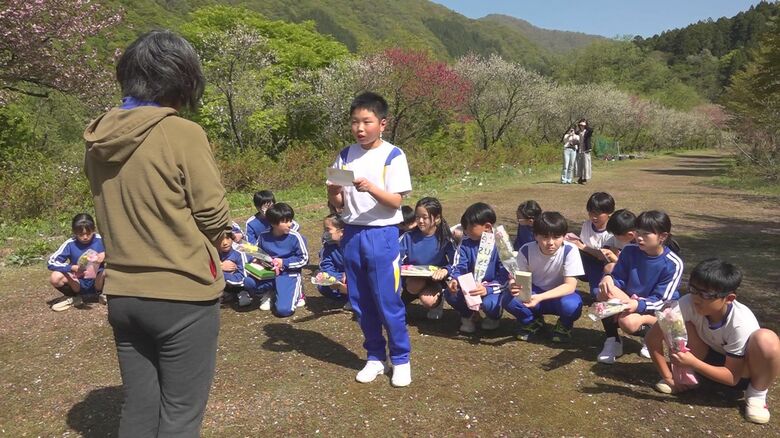 沙代子さんの家族の前で手紙を読み上げる児童