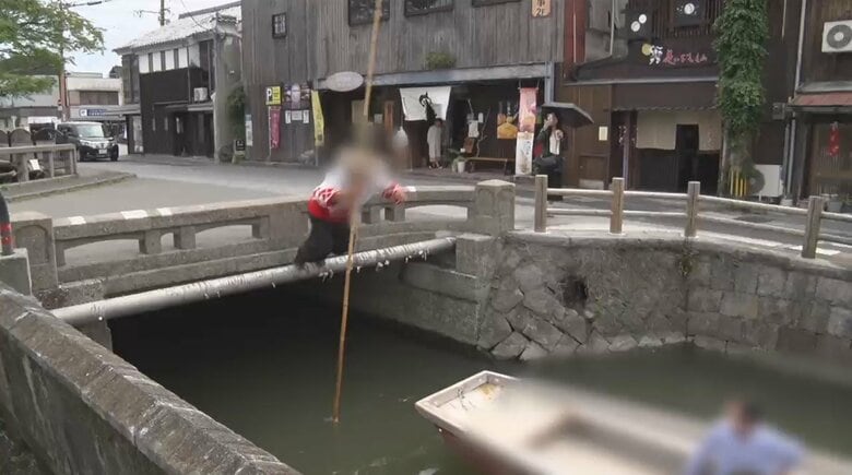 橋から舟に飛び乗る船頭