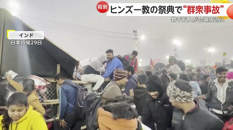 ヒンズー教の宗教行事会場で、バリケードをよじ登る人