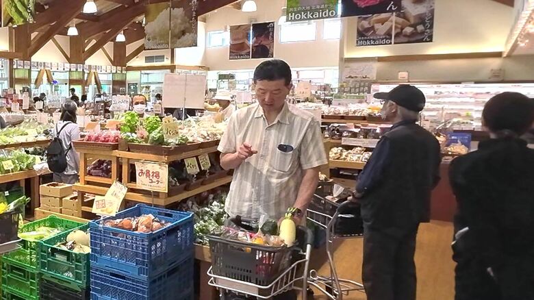 カゴいっぱいの食材をチェックする男性