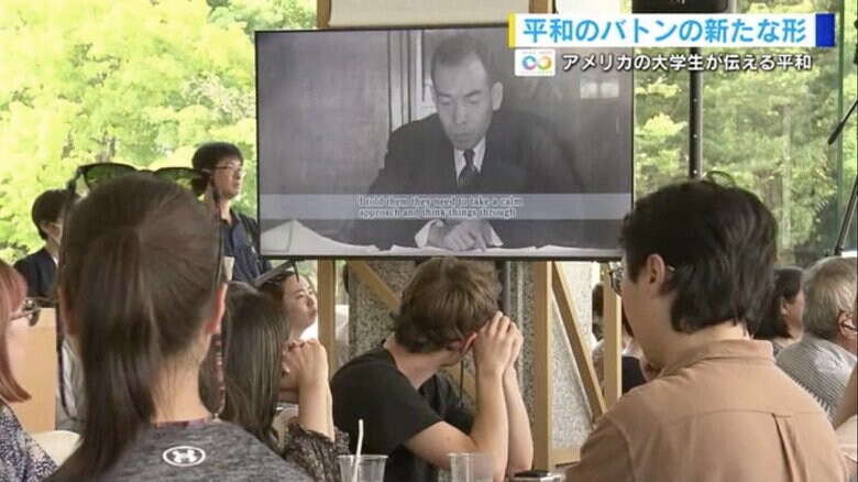 カフェに学生が英訳した浜井信三さんの映像が流れる