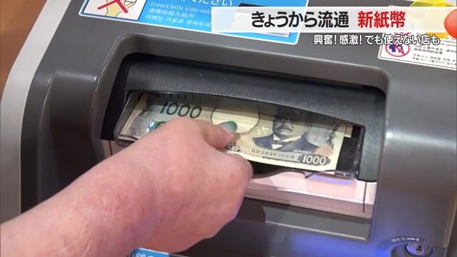 レジに新紙幣を入れる女性
