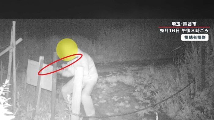 鉄の棒を持ち上げカメラに投げつける人影