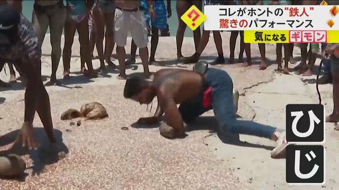 ココナッツを肘で割る男性