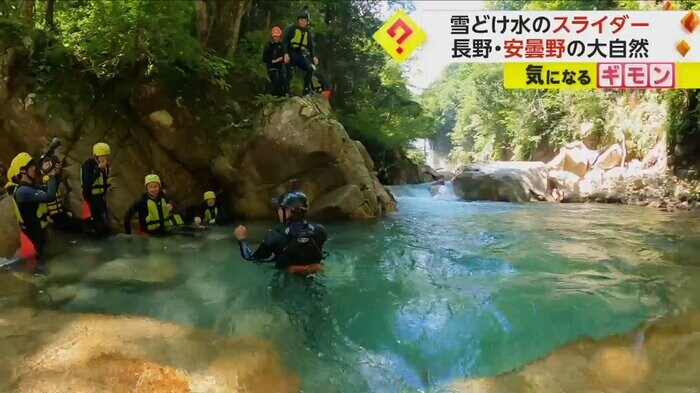 記者が岩の上に立っている