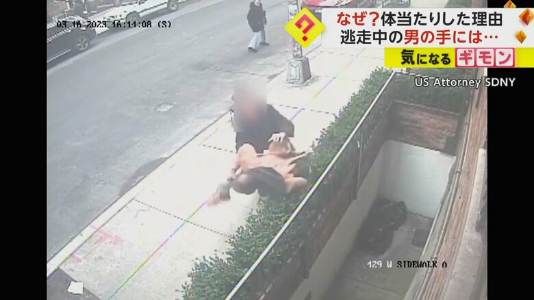 逃げようとする男を捕まえる黒い服の男性