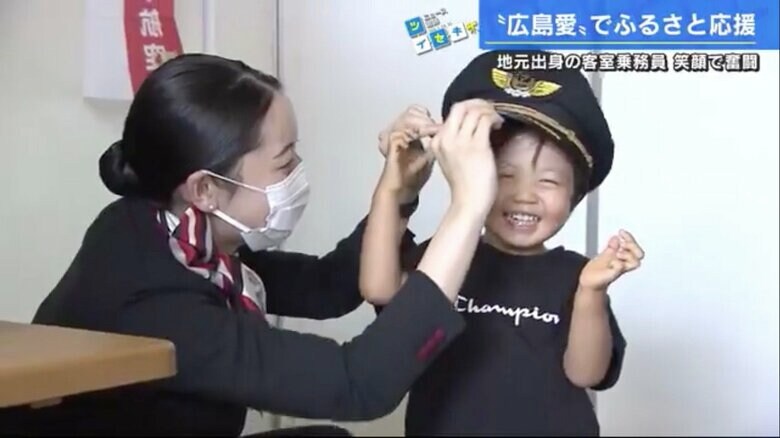 子どもにパイロットの帽子をかぶせる田地さん