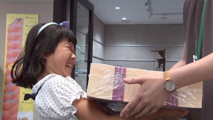 1億円の模造紙幣を持ち上げる子供