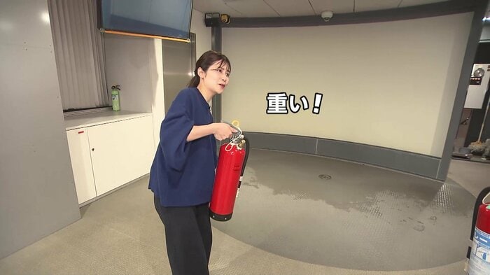 消火器の使い方を体験する竹内友佳アナウンサー